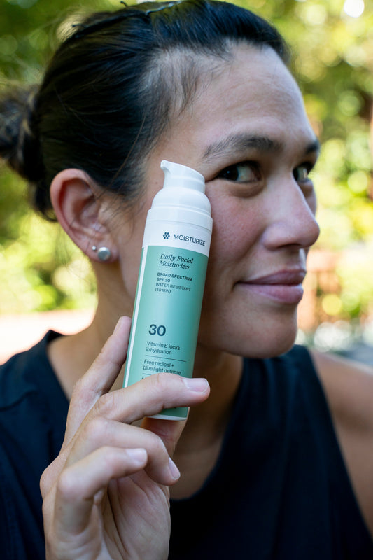 Athlete holding a bottle of sweat-resistant sunscreen to face