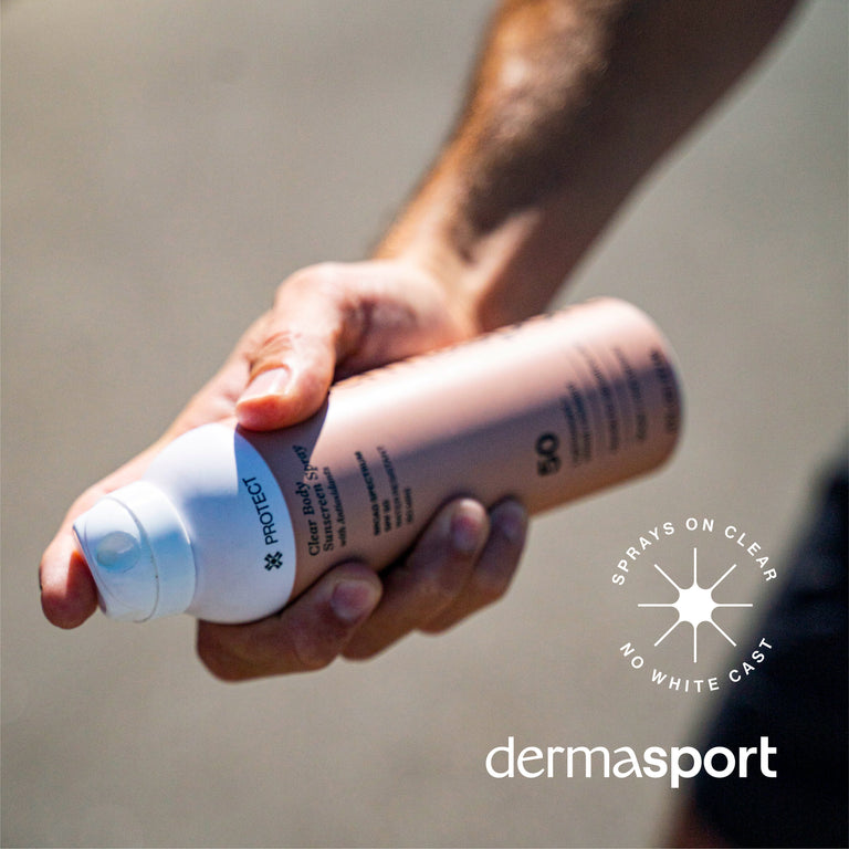 Hand holding a Dermasport spray bottle with a clear background