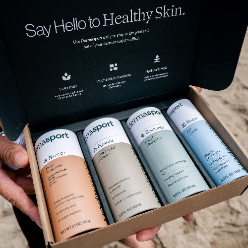 Box of Dermasport skincare products with a person holding it on a beach.
